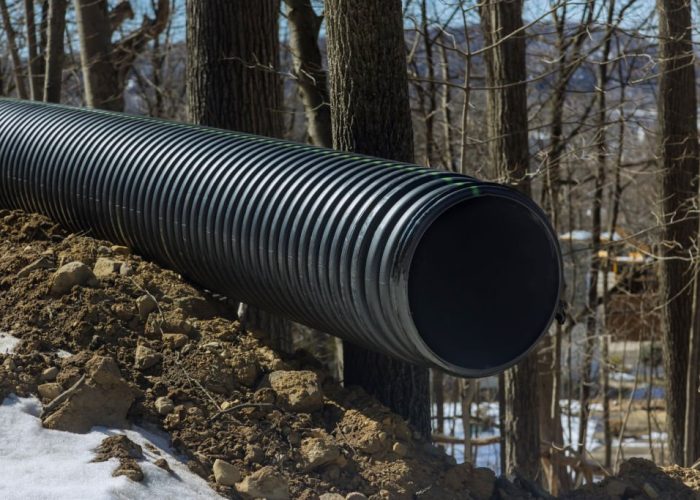 Plastic main black pipes on heap of polyethylene pipes for a drain supply system for laying urban communications of home